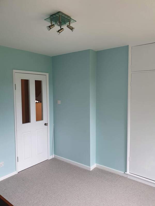 Picture of the walls and door to a master bedroom. The walls are painted in duck egg and the door and skirting boards have been glossed in white 